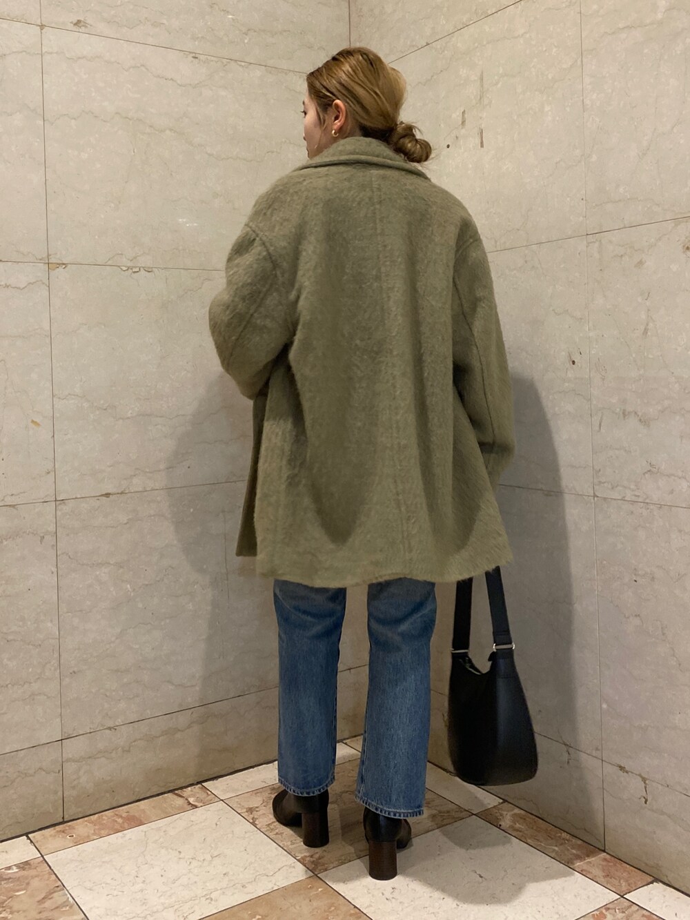ホワイト系のニット/セーター、ブルー系のTシャツ/カットソー、グリーン系のピーコートを着用したレディースの冬コーディネートの3枚目の写真