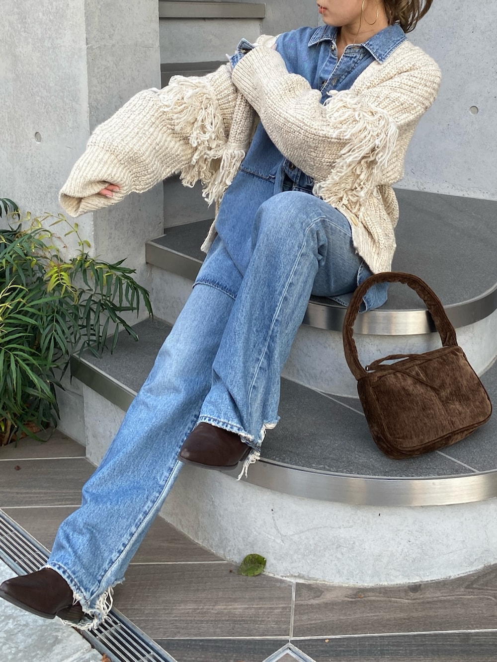 ホワイト系のカーディガン/ボレロ、ブルー系のシャツ/ブラウス、ブルー系のデニムパンツを着用したレディースの秋コーディネートの4枚目の写真