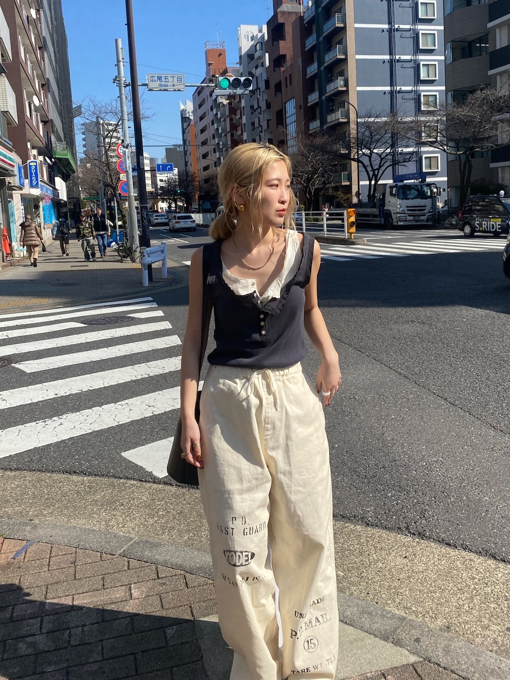 グレー系のタンクトップ、ホワイト系のタンクトップ、ホワイト系のその他パンツを着用したレディースの春コーディネートの2枚目の写真