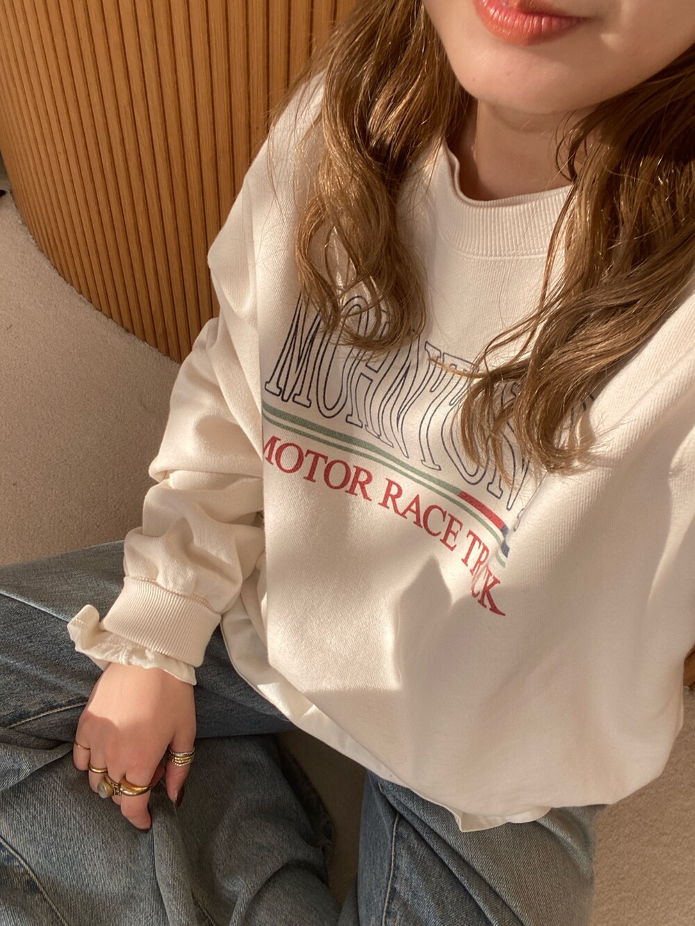 ホワイト系のスウェット、ホワイト系のTシャツ/カットソー、ブルー系のデニムパンツを着用したレディースの冬コーディネートの2枚目の写真