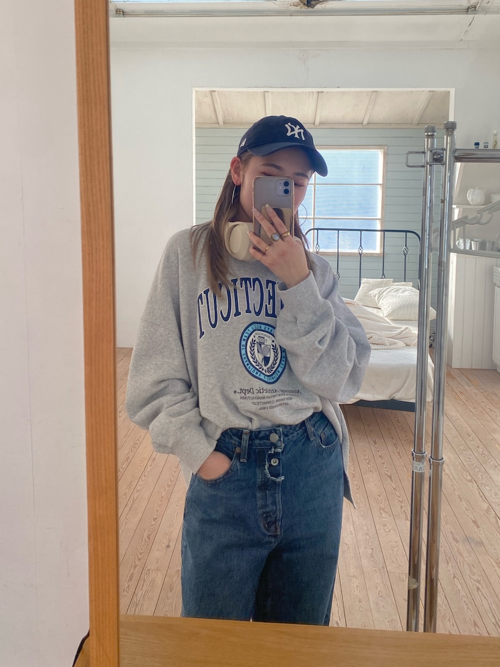 グレー系のスウェット、ブルー系のデニムパンツを着用したレディースの春コーディネートの3枚目の写真