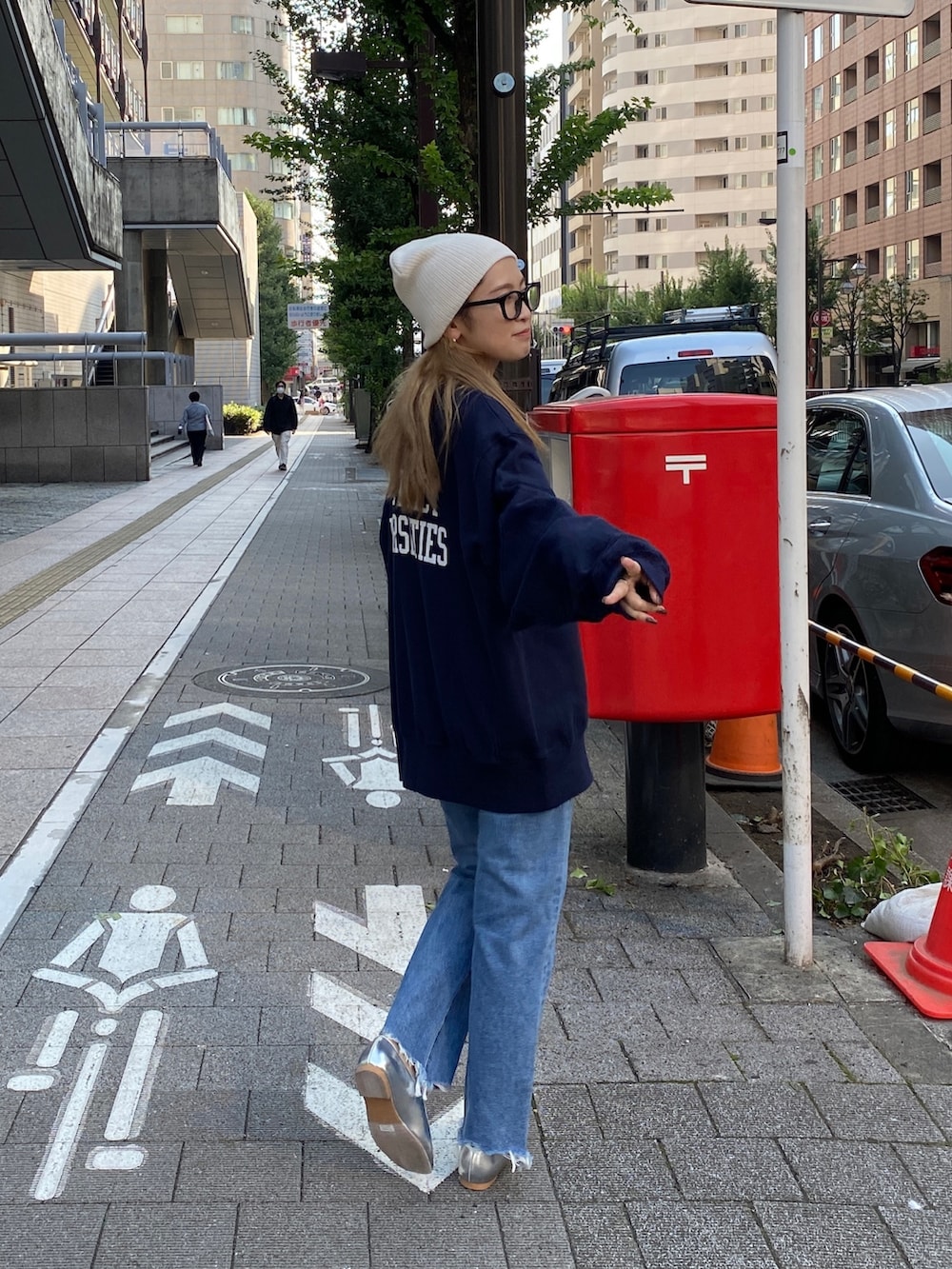 ブルー系のスウェット、ブルー系のデニムパンツ、ホワイト系のニットキャップ/ビーニーを着用したレディースの秋コーディネートの3枚目の写真