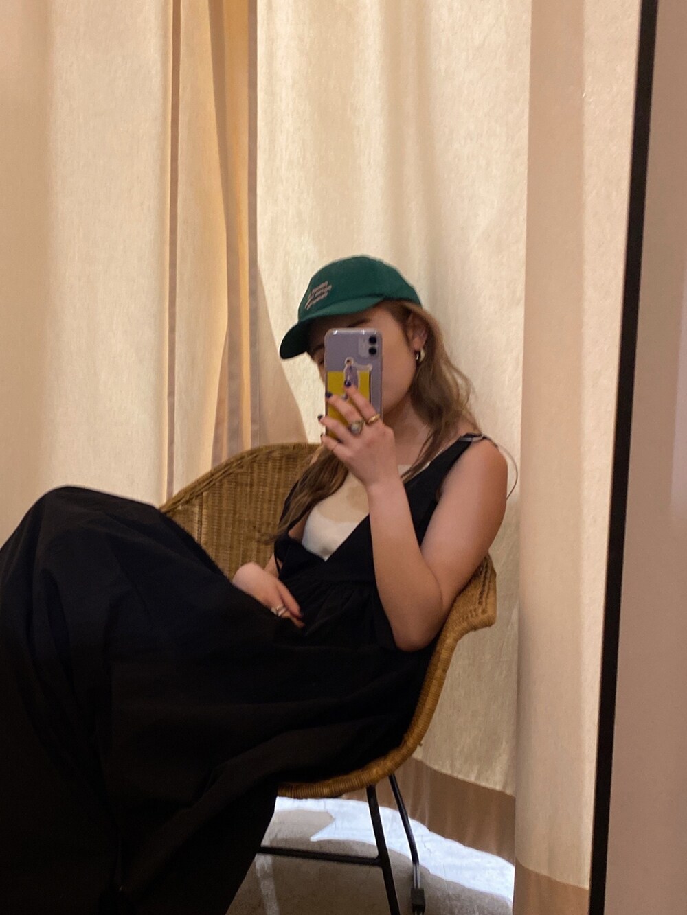 ブラック系のワンピース、ホワイト系のキャミソール、グリーン系のキャップを着用したレディースの春コーディネートの4枚目の写真