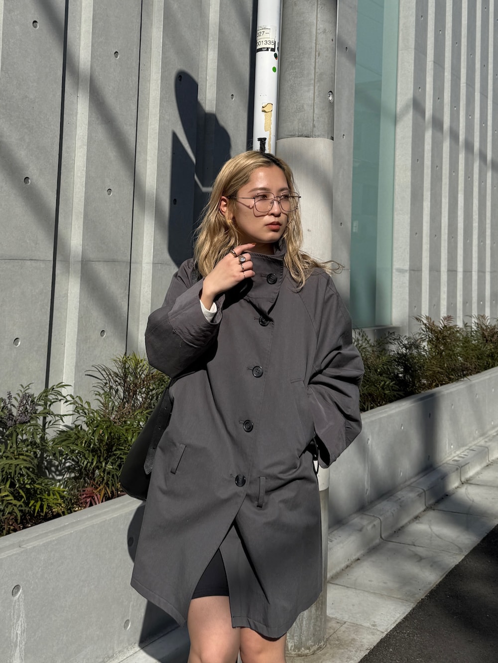 グレー系のトレンチコート、ブラック系のブーツを着用したレディースの冬コーディネートの4枚目の写真