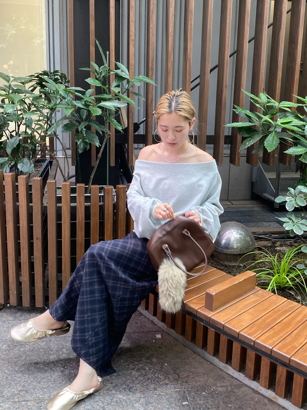 グレー系のスウェット、ブルー系のスカート、ゴールド系のバレエシューズを着用したレディースの夏コーディネートの6枚目の写真