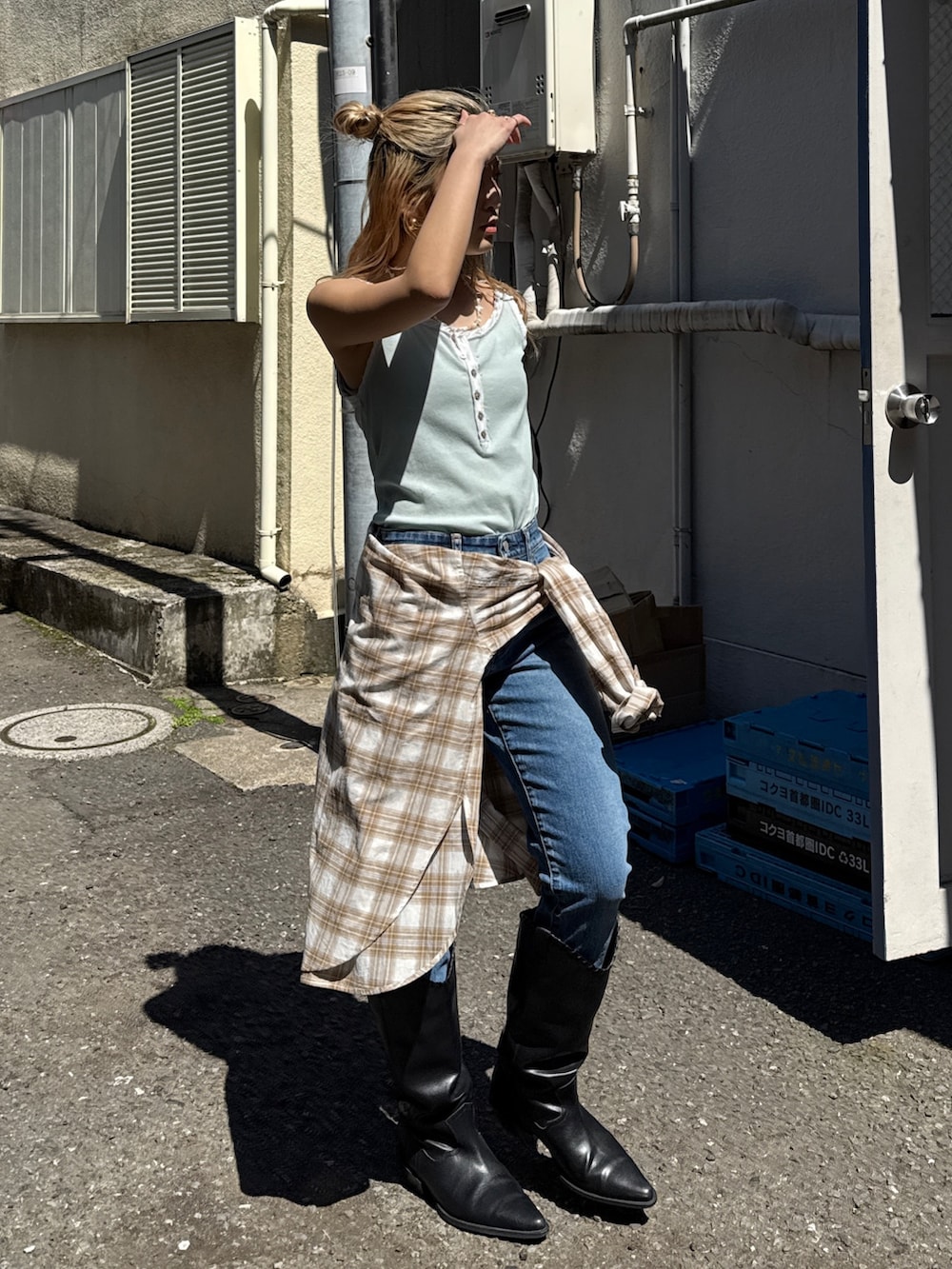 ブルー系のタンクトップ、ベージュ系のシャツ/ブラウス、ブルー系のデニムパンツを着用したレディースの春コーディネートの3枚目の写真