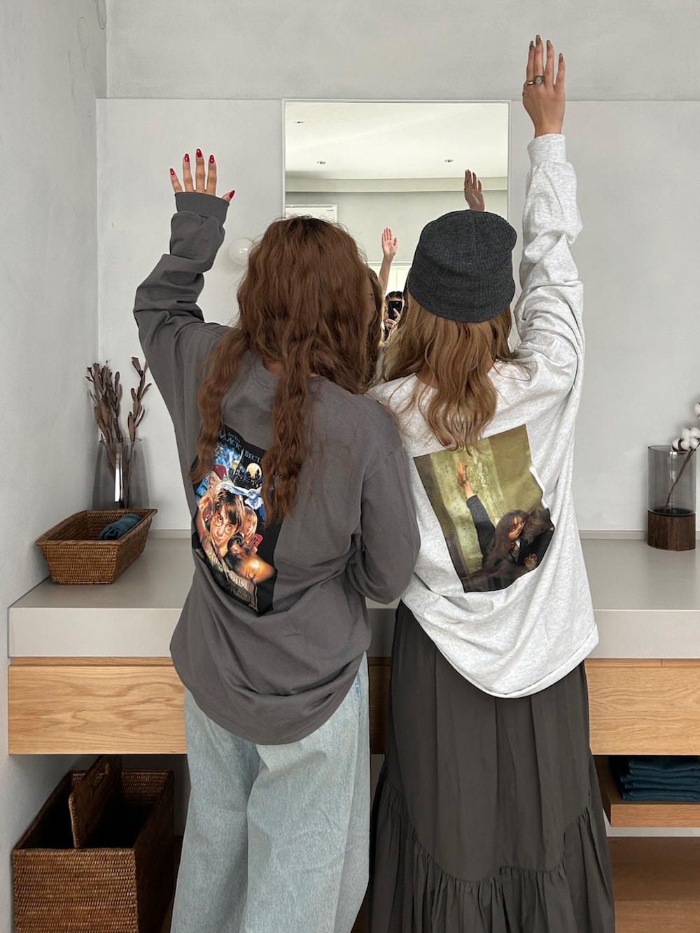 グレー系のTシャツ/カットソー、グレー系のスカート、ブルー系のデニムパンツを着用したレディースの秋コーディネートの2枚目の写真