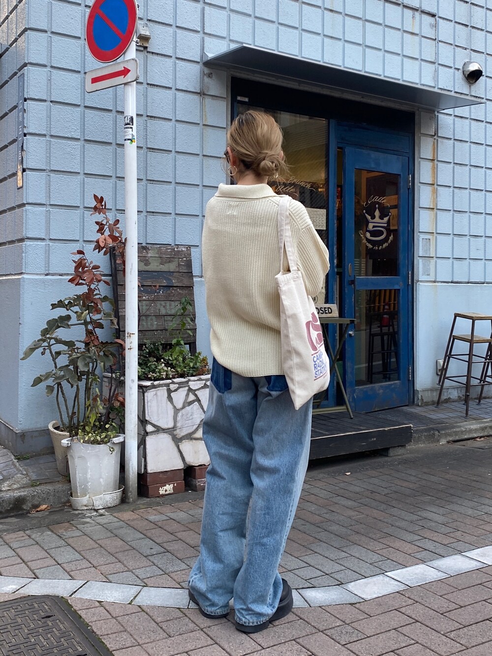 ホワイト系のニット/セーター、ブルー系のデニムパンツ、レッド系のトートバッグを着用したレディースの冬コーディネートの4枚目の写真