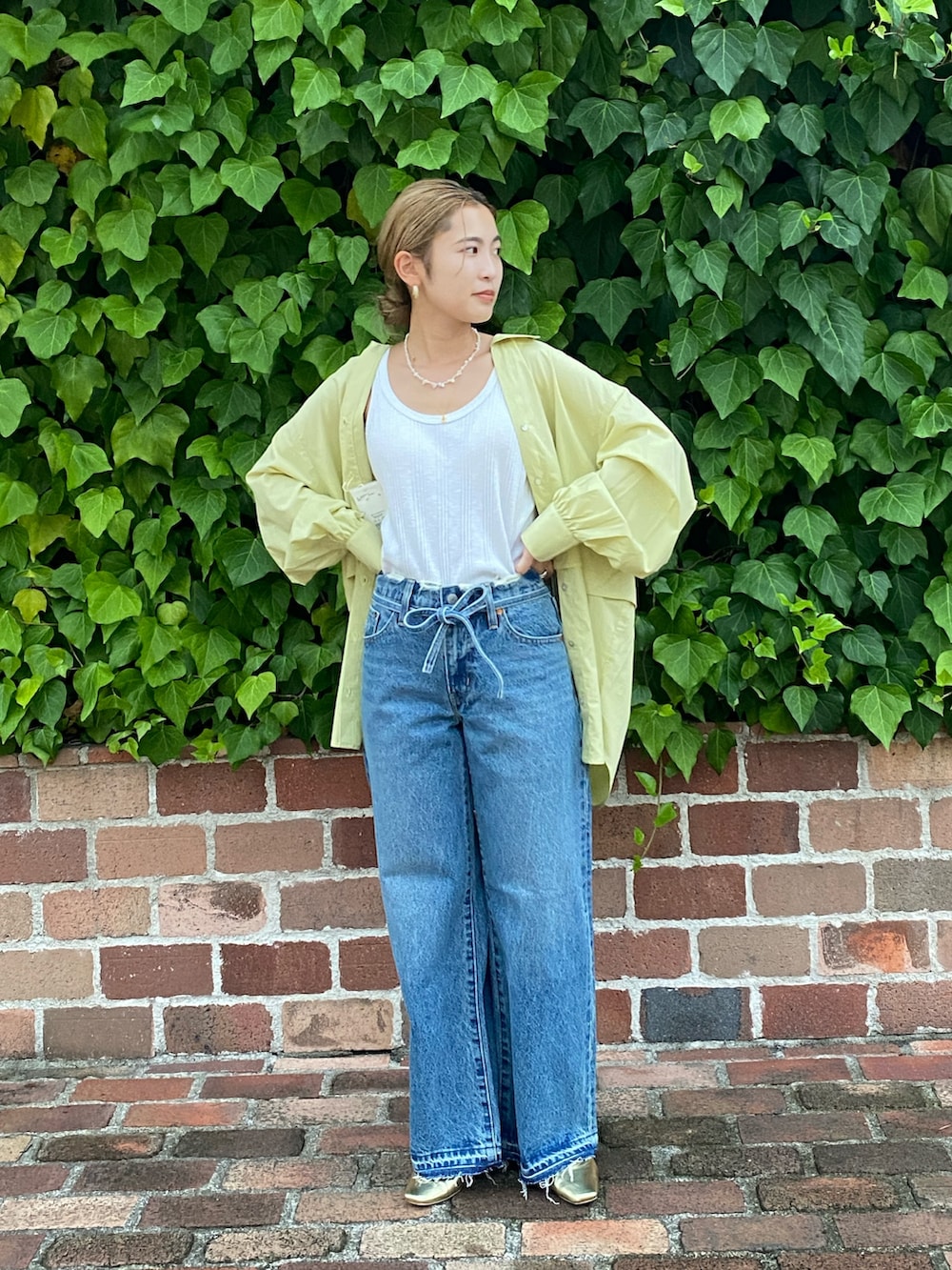 グリーン系のシャツ/ブラウス、ホワイト系のTシャツ/カットソー、ブルー系のデニムパンツを着用したレディースの夏コーディネートの2枚目の写真