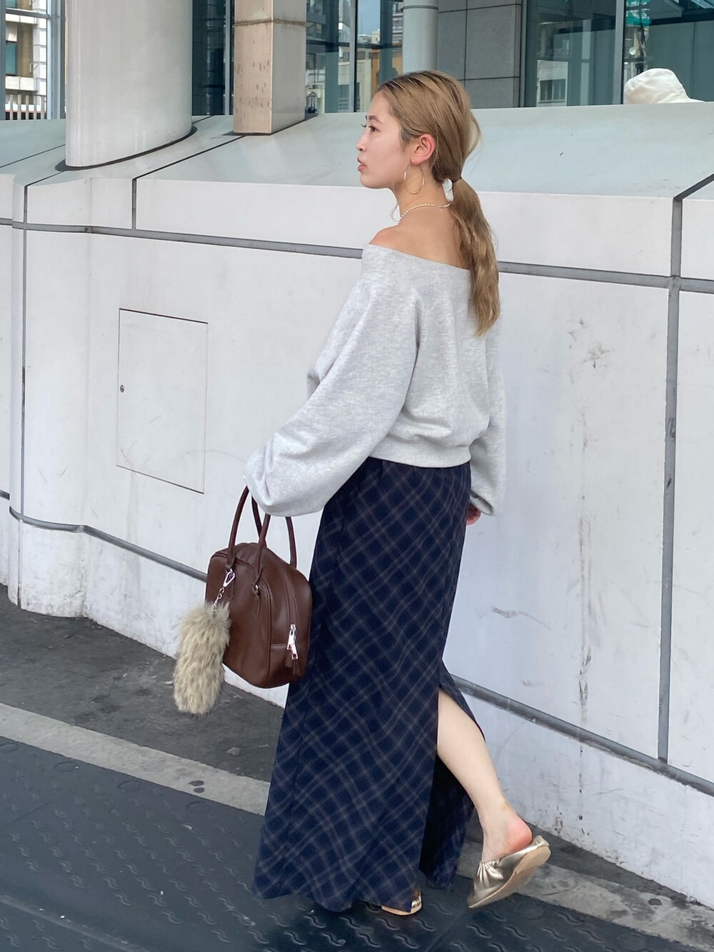 グレー系のスウェット、ブルー系のスカート、ゴールド系のバレエシューズを着用したレディースの夏コーディネートの3枚目の写真