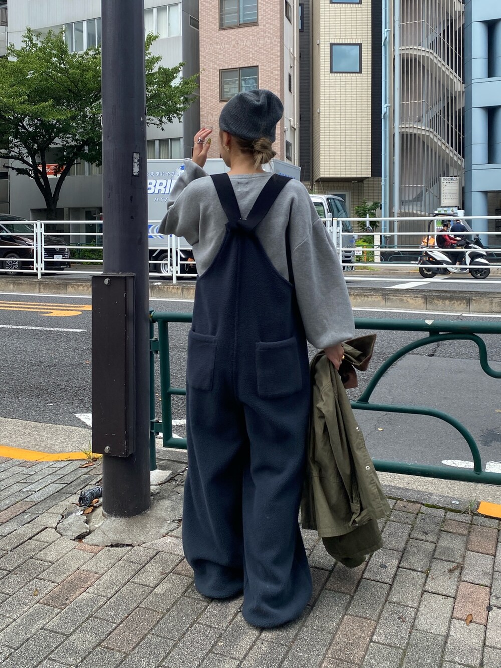 グレー系のニット/セーター、グレー系のサロペット/オーバーオール、ベージュ系のカバーオールを着用したレディースの夏コーディネートの2枚目の写真