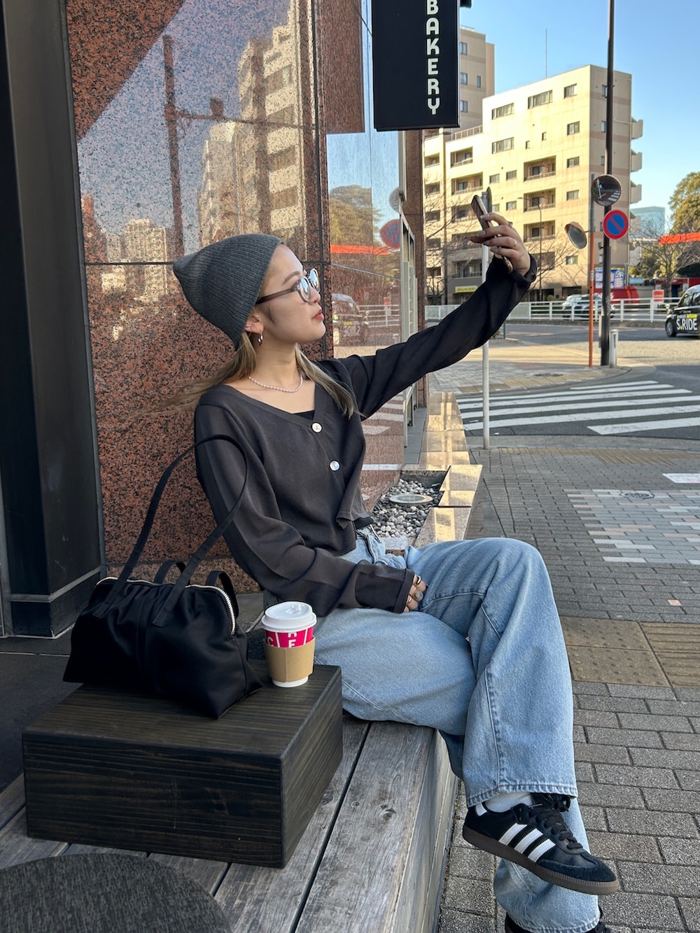 グレー系のカーディガン/ボレロ、ブラック系のキャミソール、ブルー系のデニムパンツを着用したレディースの春コーディネートの2枚目の写真