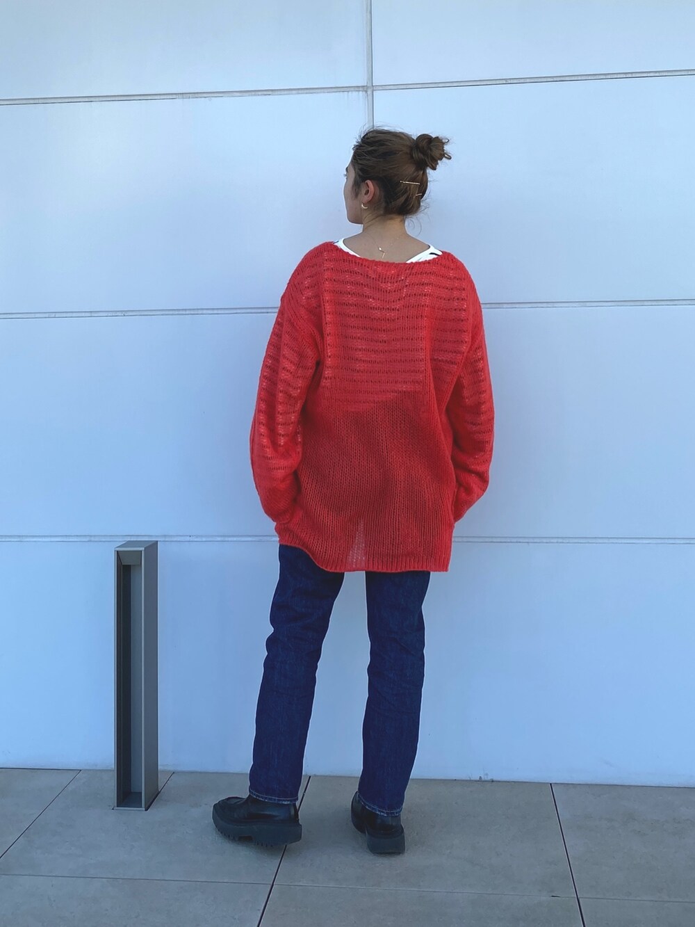 オレンジ系のニット/セーター、ブルー系のTシャツ/カットソーを着用したレディースの冬コーディネートの3枚目の写真