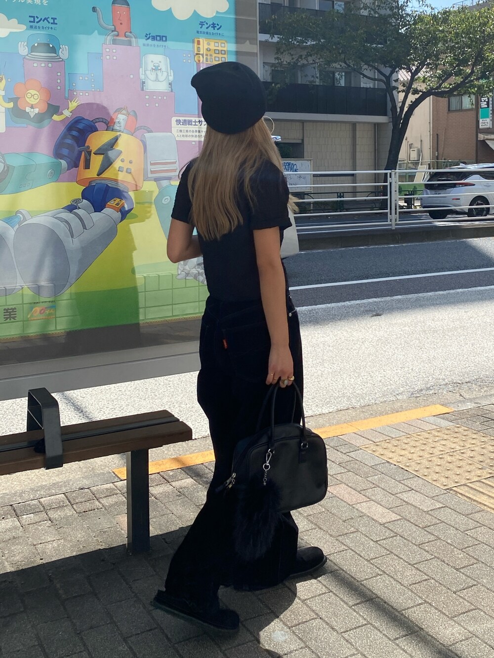 ブラック系のポロシャツ、ブラック系のデニムパンツ、ブラック系のスリッポンを着用したレディースの秋コーディネートの2枚目の写真