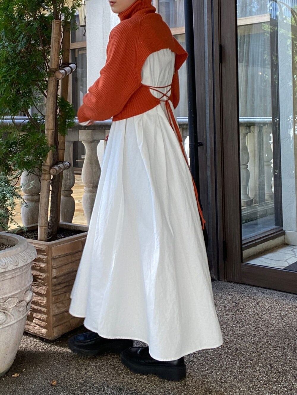 オレンジ系のワンピースを着用したレディースの秋コーディネートの3枚目の写真