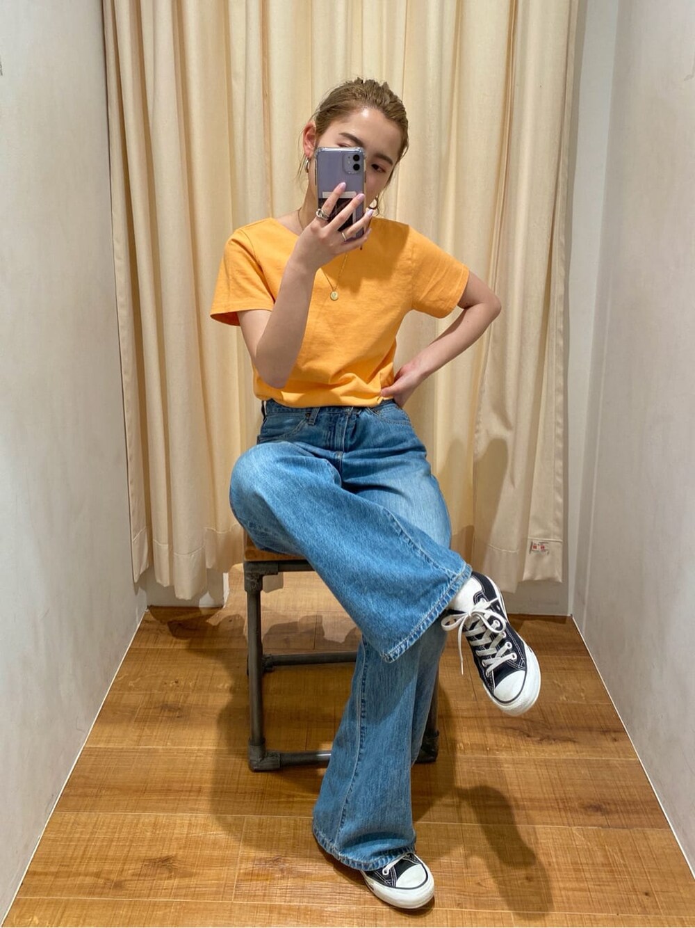 ブルー系のデニムパンツ、ホワイト系のキャミソール、レッド系のハンドバッグを着用したレディースの春コーディネートの3枚目の写真