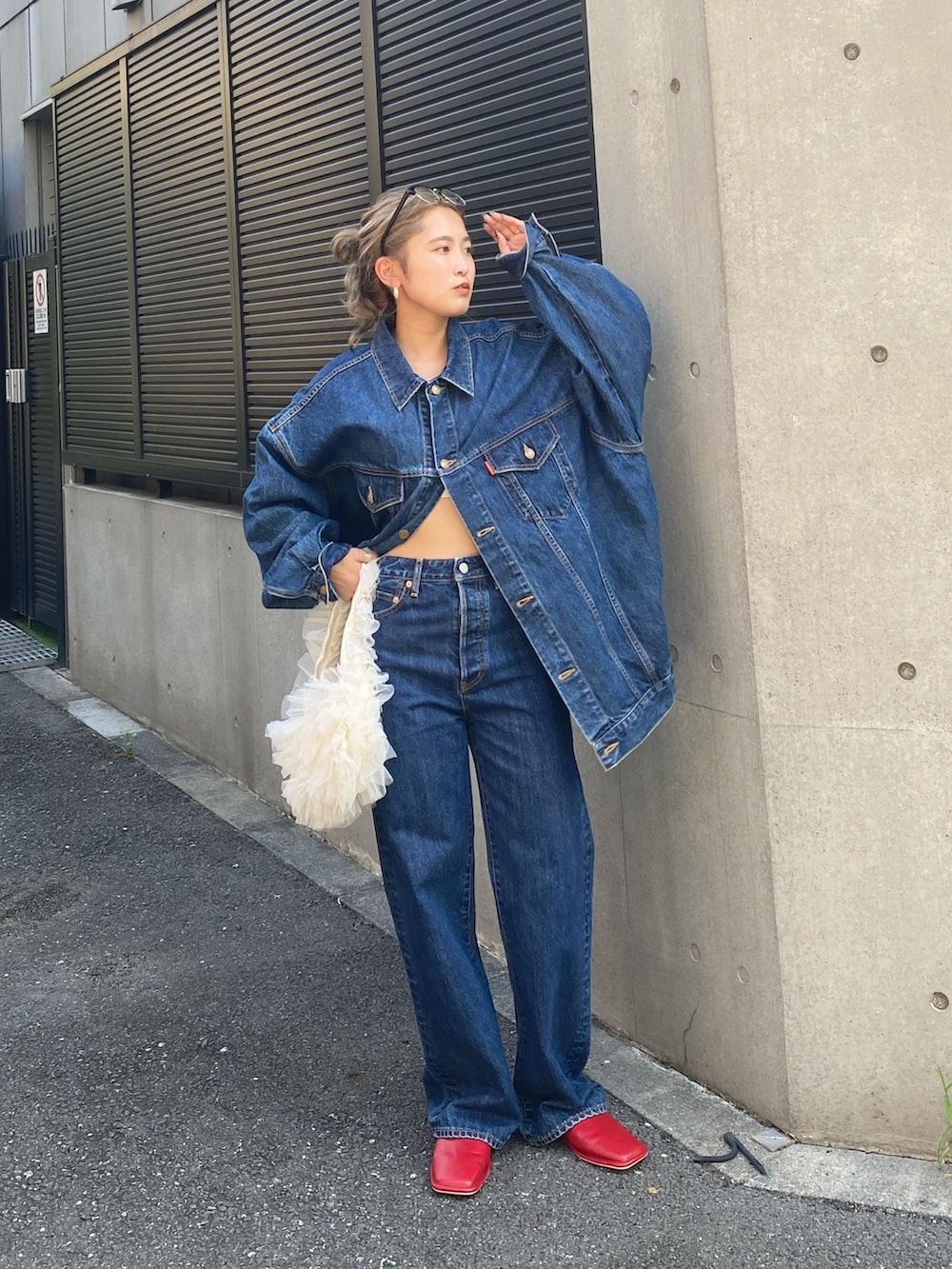 ブルー系のデニムジャケット、ブルー系のデニムパンツ、ホワイト系のショルダーバッグを着用したレディースの夏コーディネートの3枚目の写真