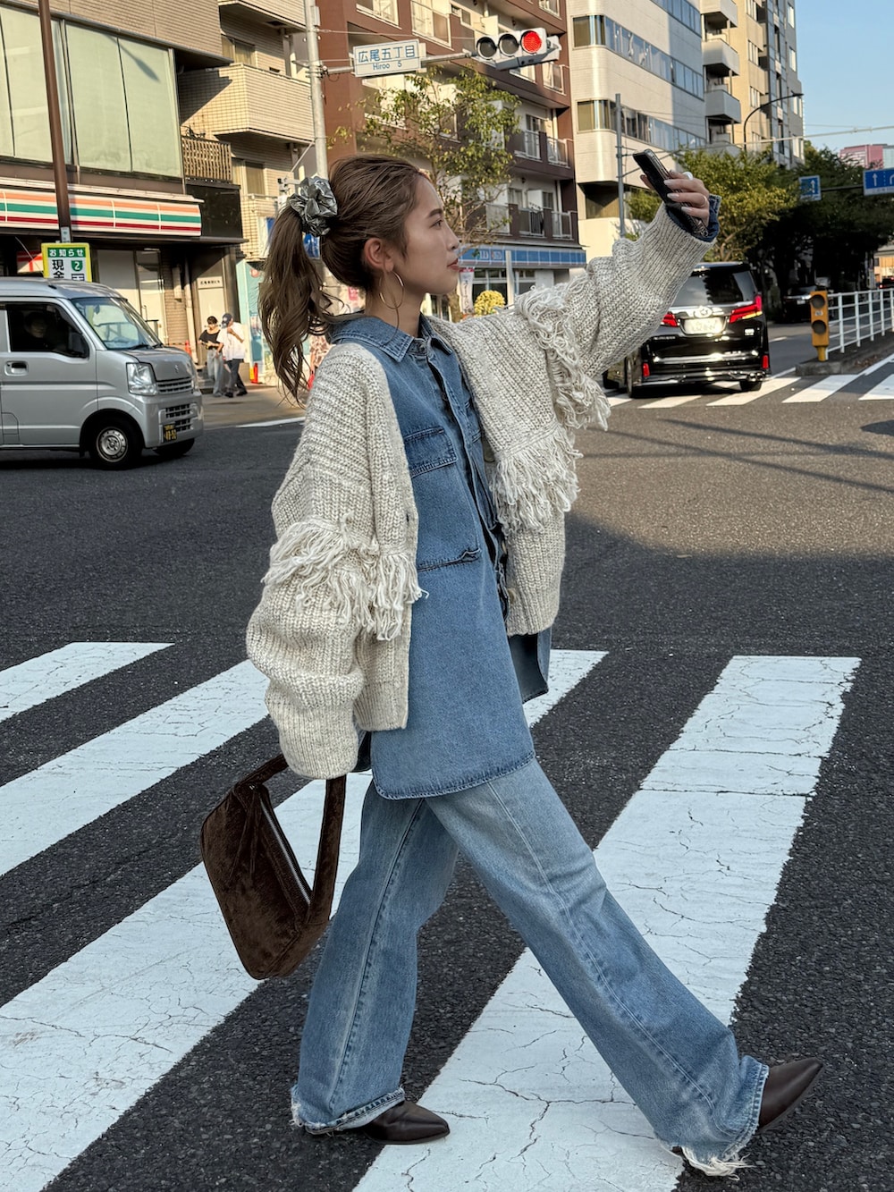 ホワイト系のカーディガン/ボレロ、ブルー系のシャツ/ブラウス、ブルー系のデニムパンツを着用したレディースの秋コーディネートの2枚目の写真