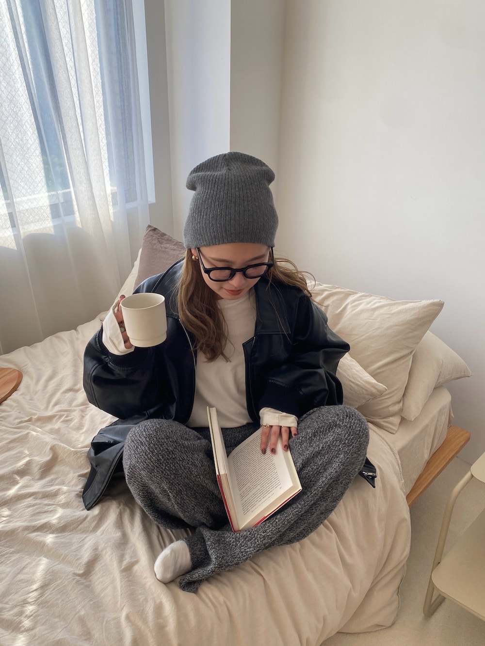 ブラック系のブルゾン、グレー系のその他パンツ、ホワイト系のTシャツ/カットソーを着用したレディースの冬コーディネートの2枚目の写真