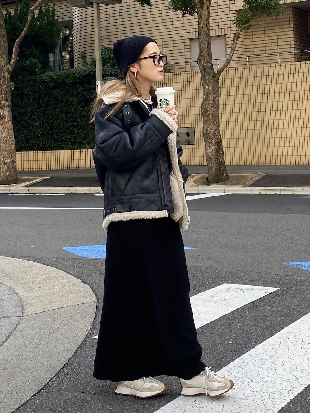 ブラック系のムートンコート、ブラック系のワンピース、ブラック系のニットキャップ/ビーニーを着用したレディースの冬コーディネートの2枚目の写真