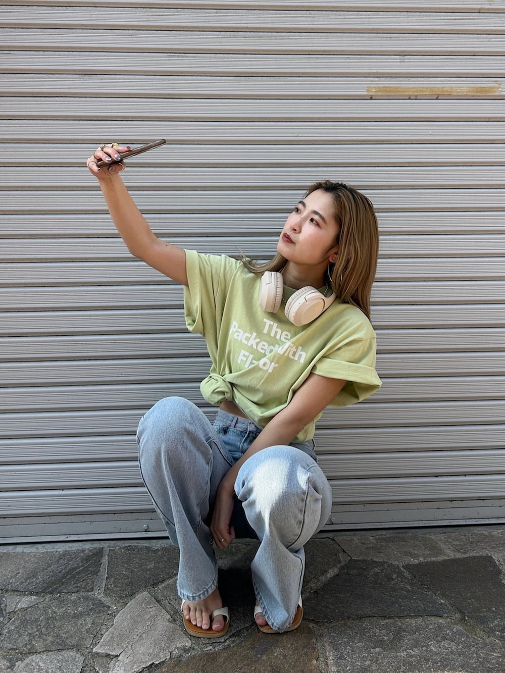 ブルー系のデニムパンツ、グリーン系のTシャツ/カットソー、ホワイト系のサンダルを着用したレディースの春コーディネートの4枚目の写真