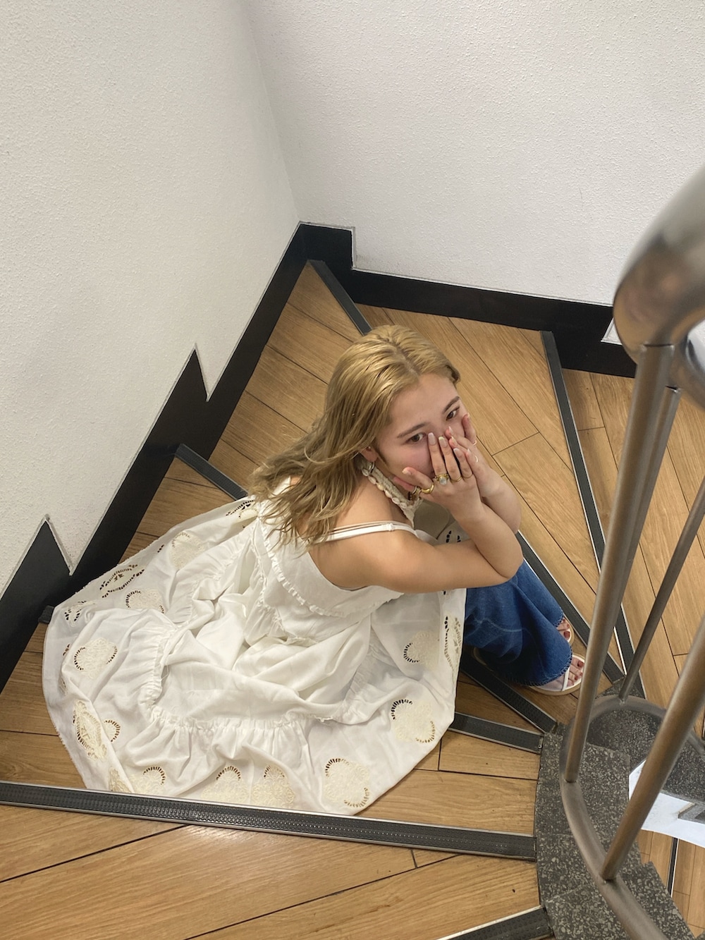 ホワイト系のワンピース、ホワイト系のタンクトップ、ブルー系のデニムパンツを着用したレディースの春コーディネートの4枚目の写真