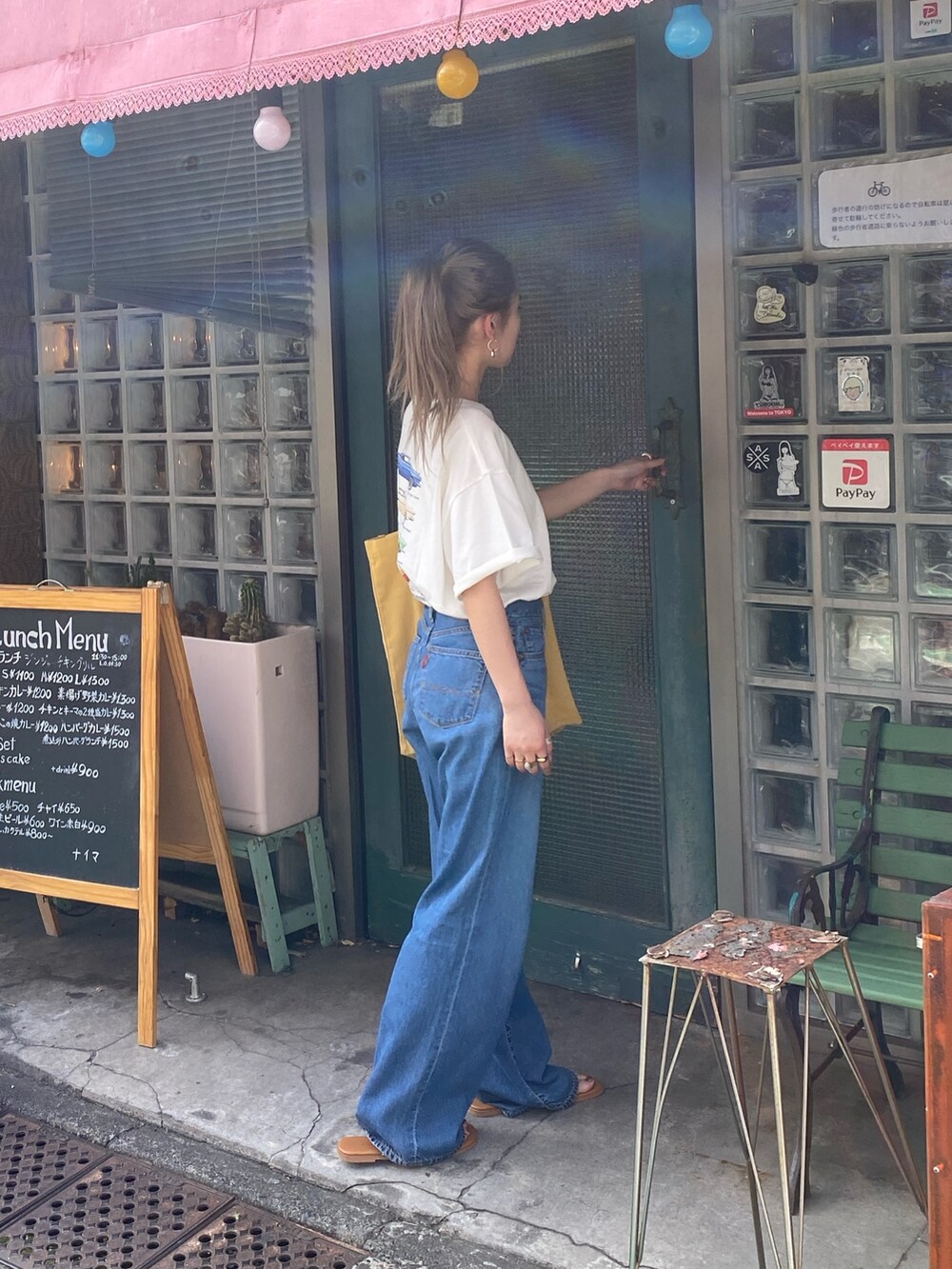 ホワイト系のTシャツ/カットソー、ブルー系のデニムパンツ、イエロー系のトートバッグを着用したレディースの春コーディネートの4枚目の写真