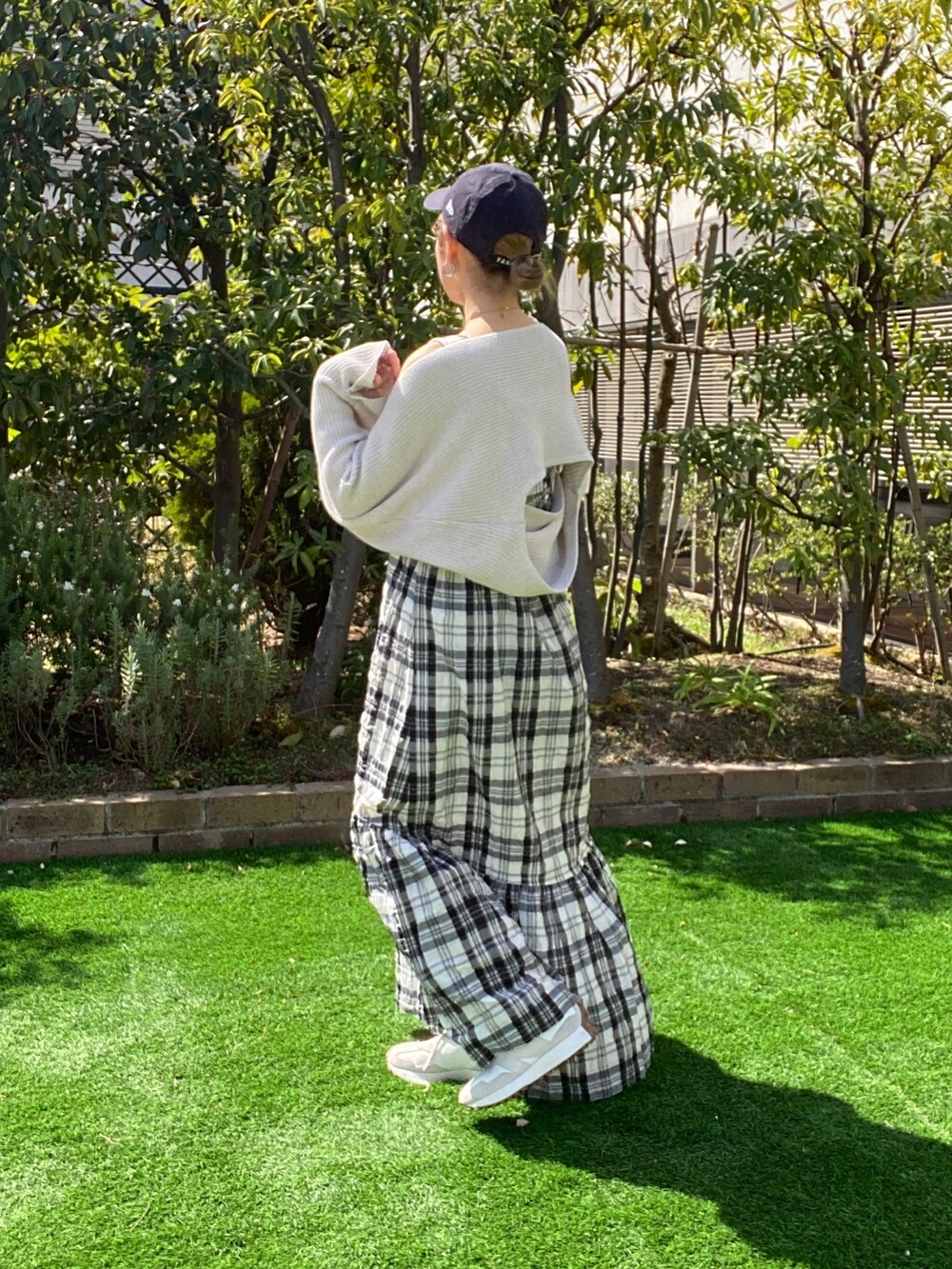 ホワイト系のニット/セーター、ブラック系のワンピース、ブラック系のハンドバッグを着用したレディースの春コーディネートの5枚目の写真