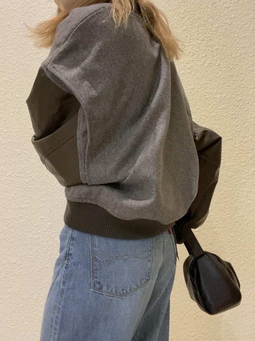 グレー系のブルゾン、ホワイト系のニット/セーター、ブルー系のデニムパンツを着用したレディースの秋コーディネートの5枚目の写真