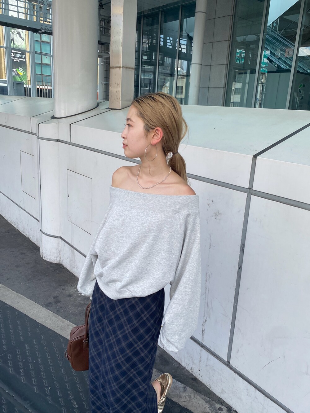 グレー系のスウェット、ブルー系のスカート、ゴールド系のバレエシューズを着用したレディースの夏コーディネートの4枚目の写真