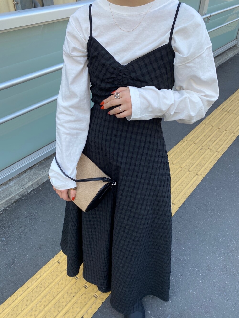 ホワイト系のTシャツ/カットソー、ブラック系のワンピース、ブラック系のブーツを着用したレディースの冬コーディネートの4枚目の写真