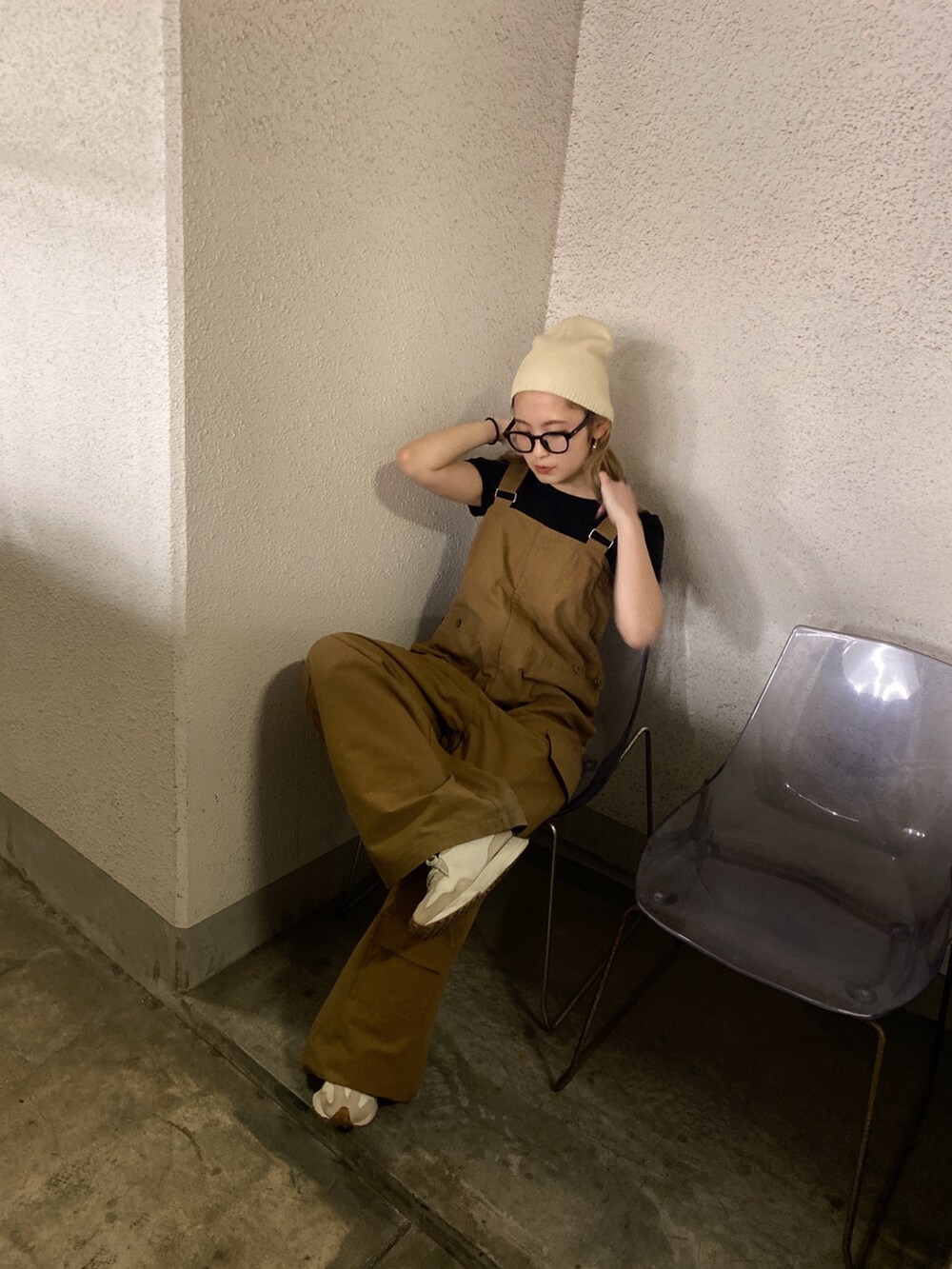 イエロー系のつなぎ/オールインワン、ホワイト系のニットキャップ/ビーニー、ブラック系のメガネを着用したレディースの春コーディネートの2枚目の写真