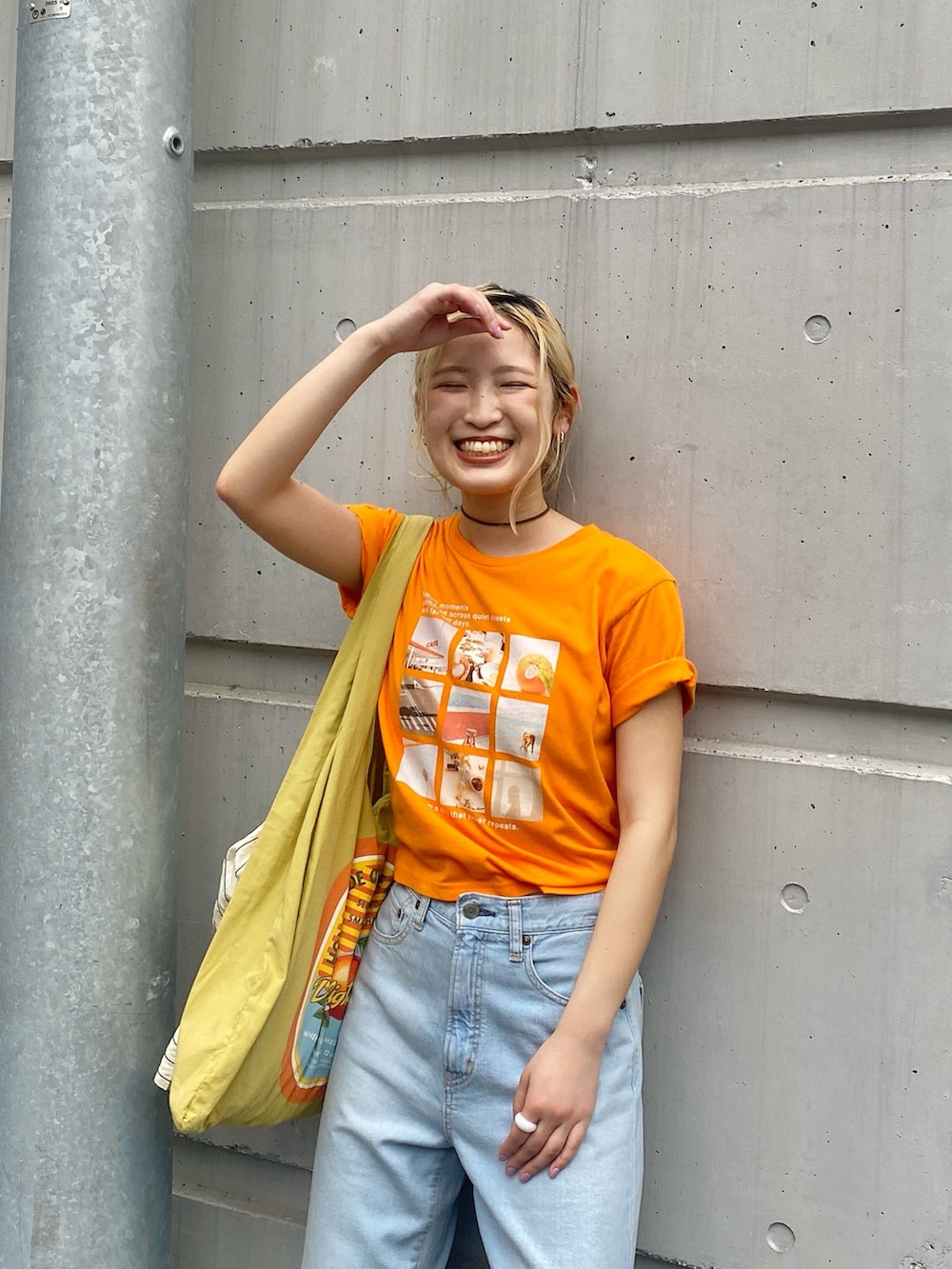 オレンジ系のTシャツ/カットソー、ブルー系のデニムパンツ、その他のサンダルを着用したレディースの春コーディネートの3枚目の写真