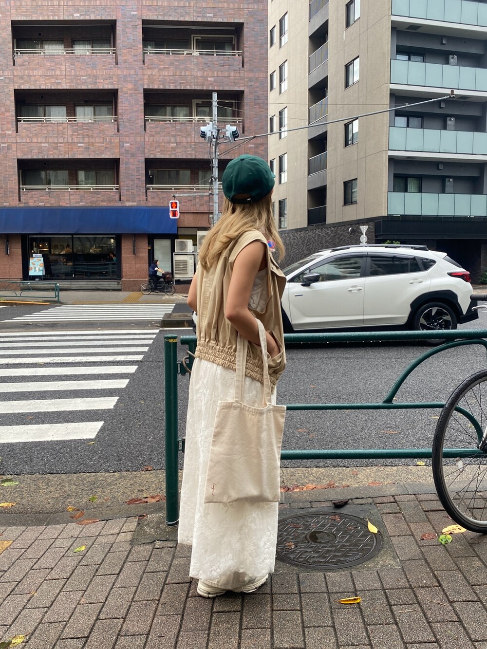 ベージュ系のベスト、ホワイト系のワンピース、ホワイト系のTシャツ/カットソーを着用したレディースの夏コーディネートの3枚目の写真