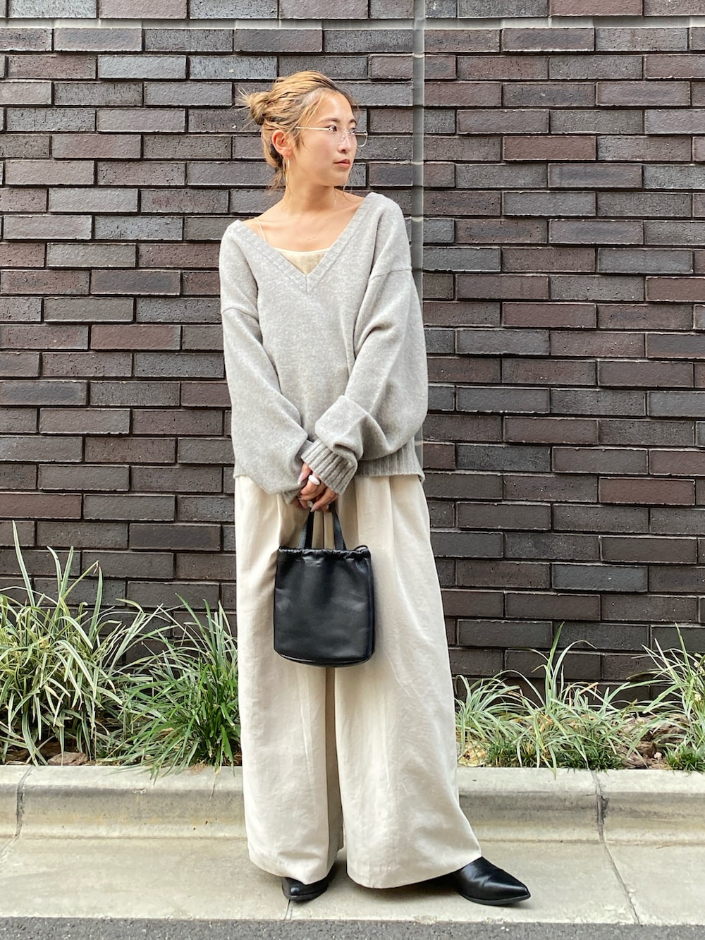 グレー系のニット/セーター、ホワイト系のその他パンツ、ブラック系のショルダーバッグを着用したレディースの秋コーディネートの2枚目の写真