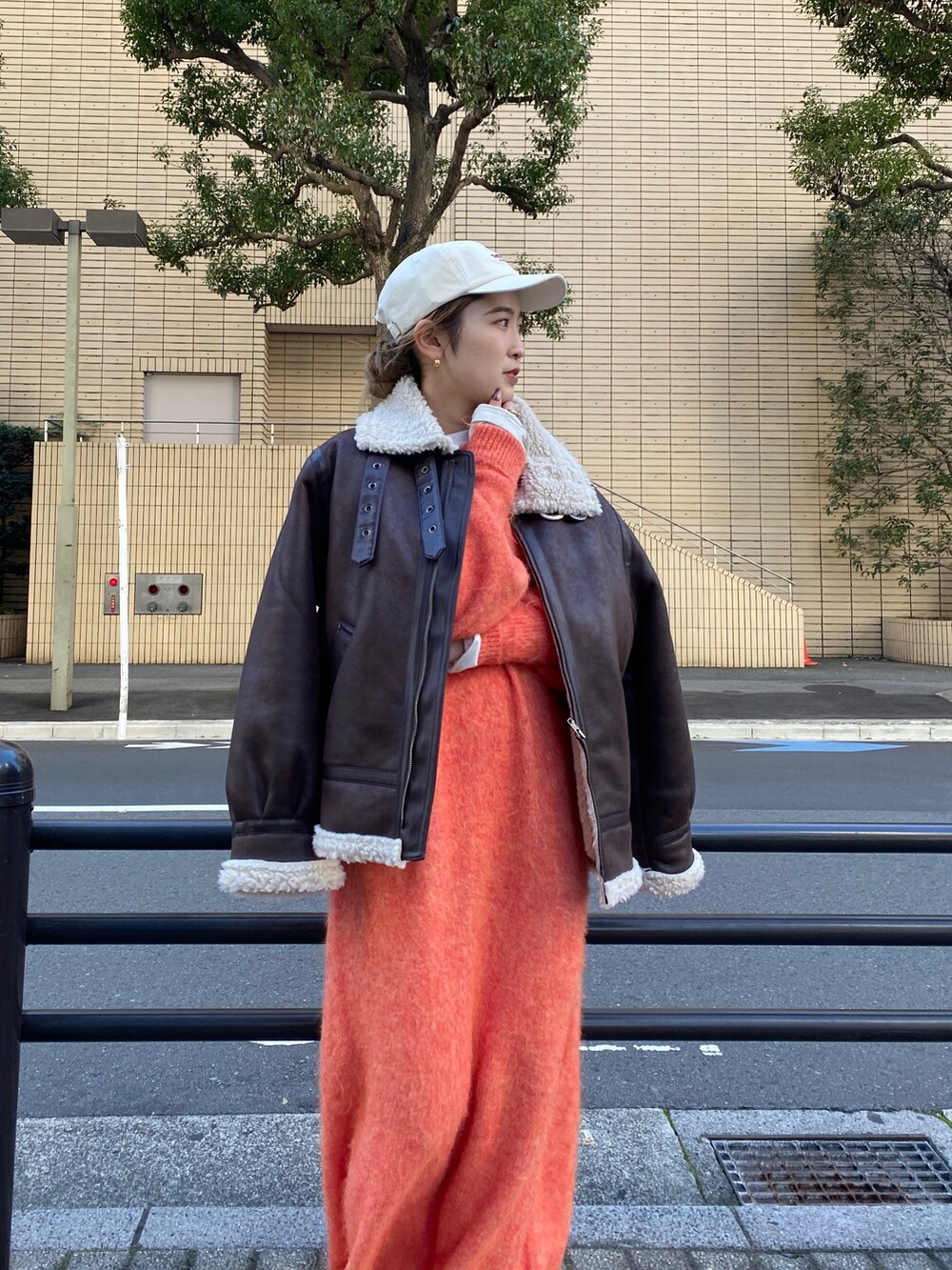 オレンジ系のワンピース、ブラウン系のブルゾン、ホワイト系のTシャツ/カットソーを着用したレディースの冬コーディネートの2枚目の写真