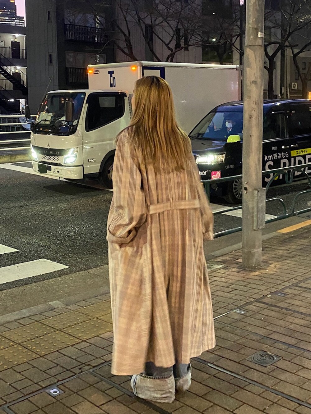 その他のステンカラーコート、ブルー系のデニムパンツ、ピンク系のTシャツ/カットソーを着用したレディースの冬コーディネートの2枚目の写真
