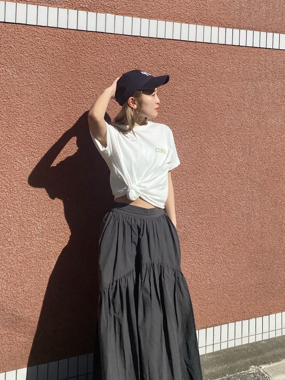 ホワイト系のTシャツ/カットソー、ブルー系のデニムジャケット、グレー系のスカートを着用したレディースの春コーディネートの5枚目の写真