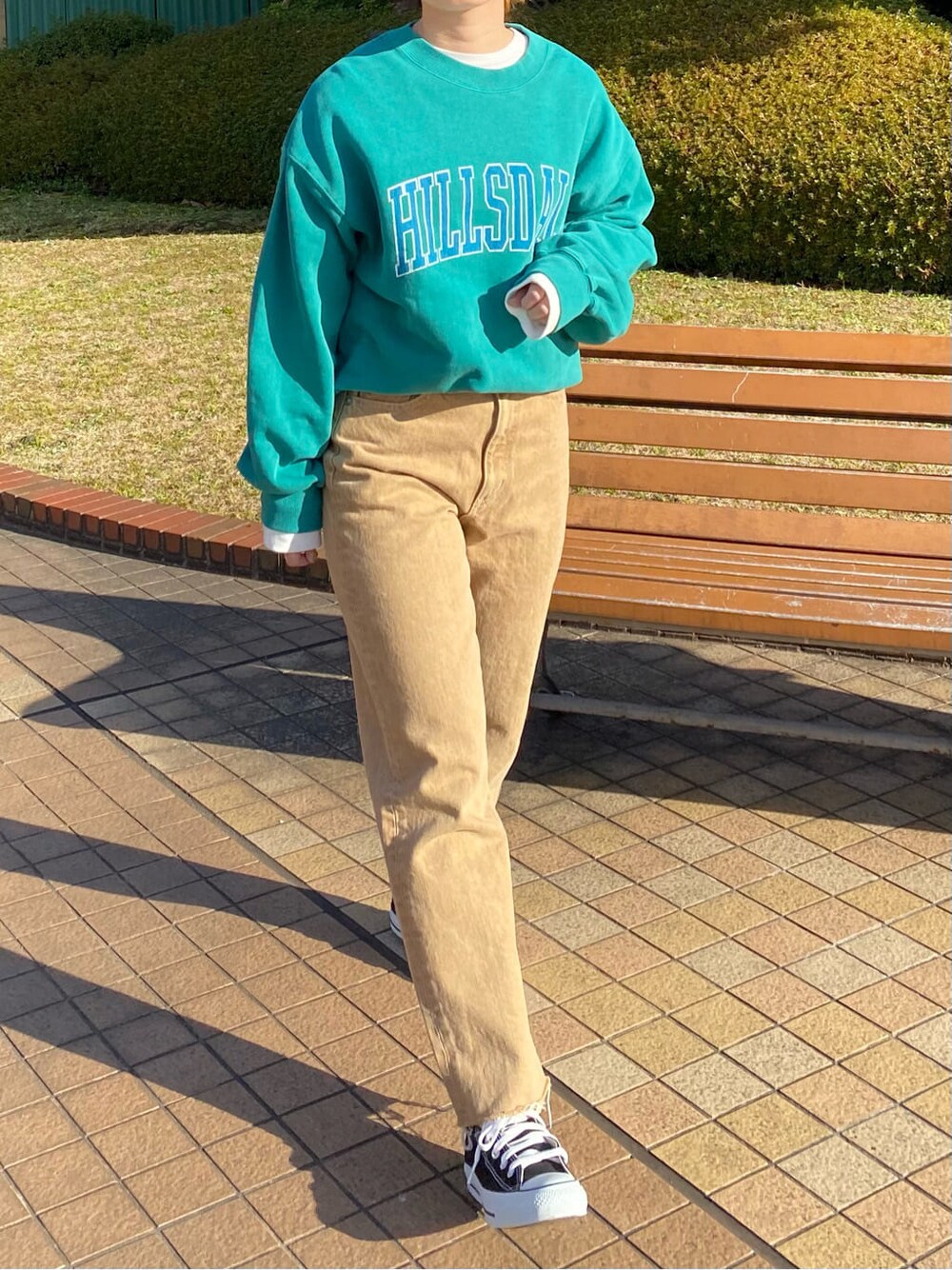 ホワイト系のTシャツ/カットソー、ベージュ系のデニムパンツ、グリーン系のスウェットを着用したレディースの冬コーディネートの4枚目の写真