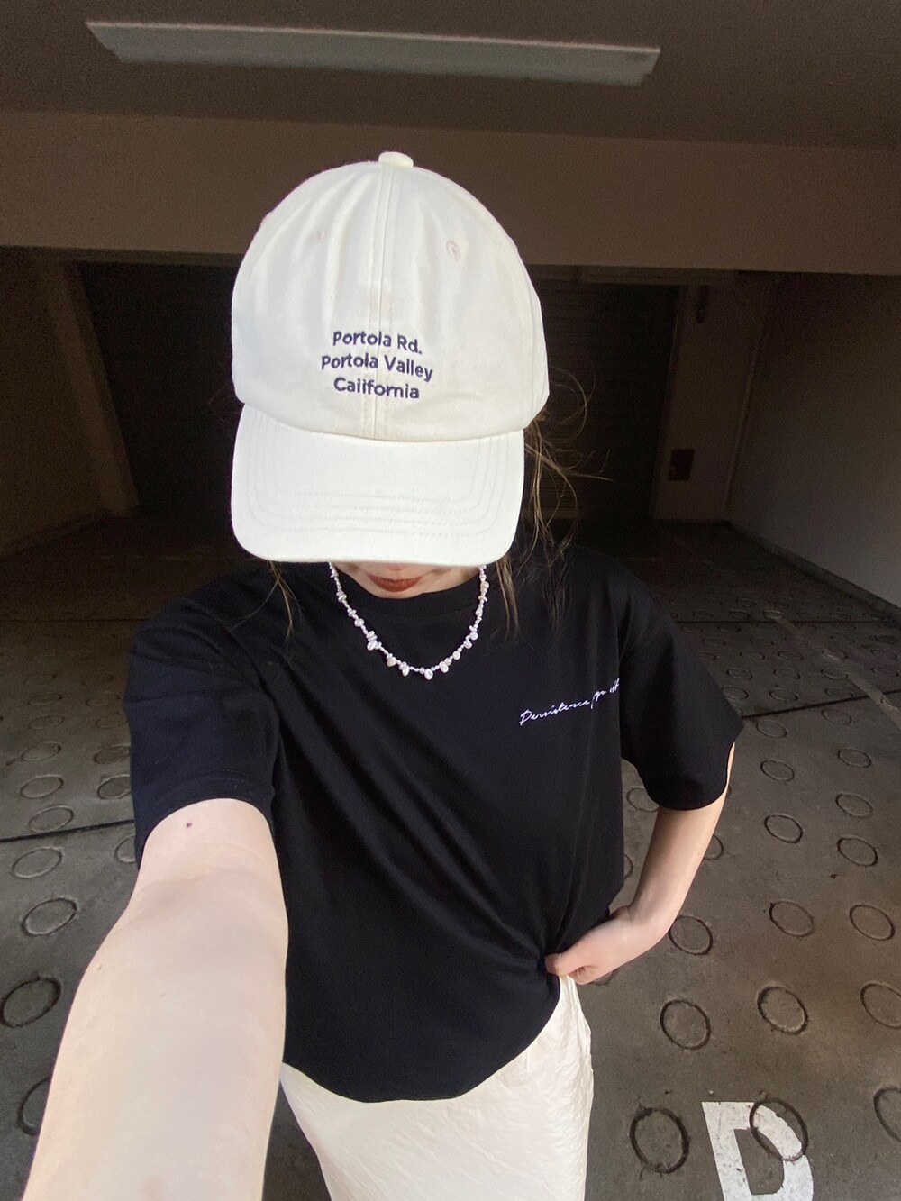 ブラック系のTシャツ/カットソー、ホワイト系のスカート、ホワイト系のサンダルを着用したレディースの春コーディネートの2枚目の写真