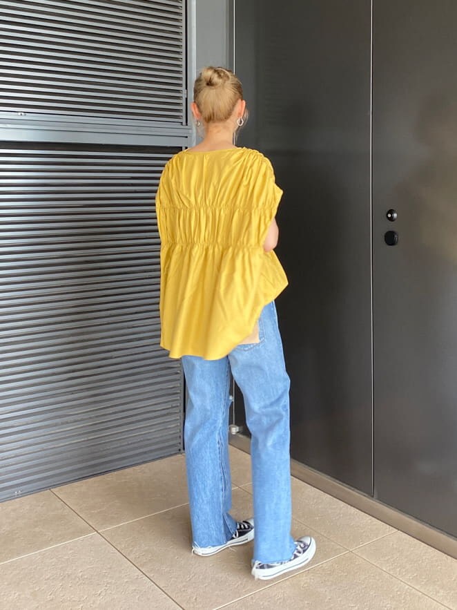 ブルー系のデニムパンツ、イエロー系のシャツ/ブラウス、ブラック系のキャミソールを着用したレディースの夏コーディネートの3枚目の写真