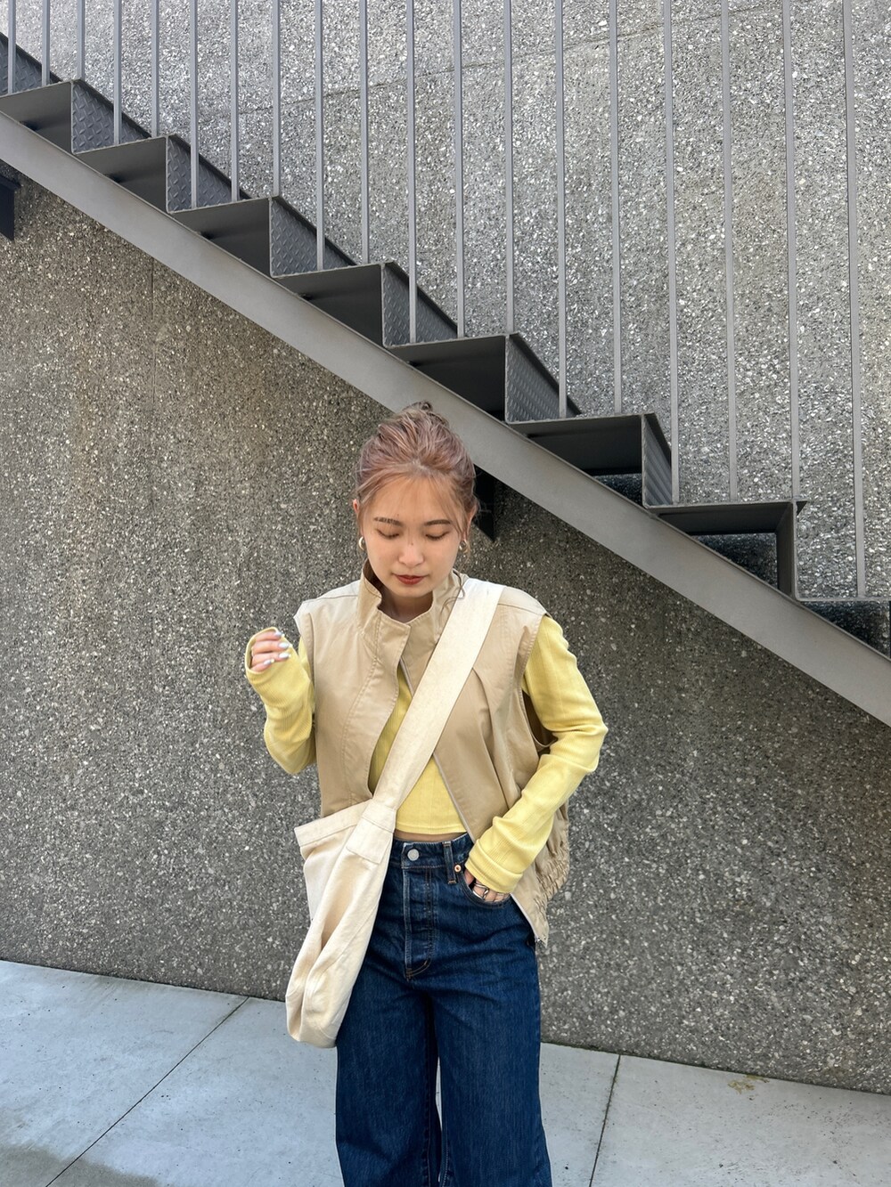 ブルー系のショルダーバッグ、ベージュ系のベスト、グリーン系のTシャツ/カットソーを着用したレディースの夏コーディネートの4枚目の写真