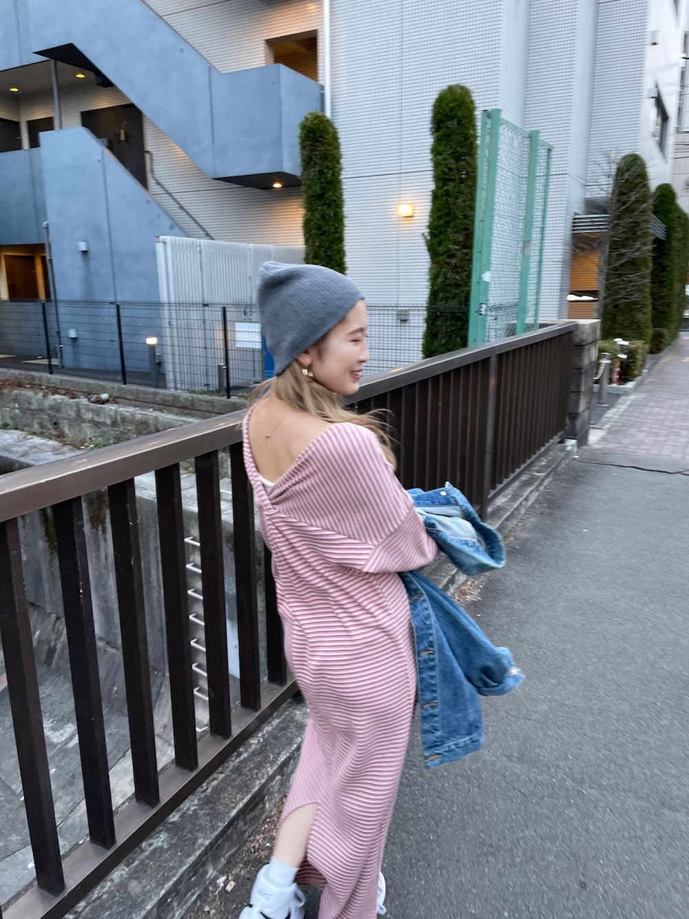 ピンク系のワンピース、ブルー系のデニムジャケット、グレー系のニットキャップ/ビーニーを着用したレディースの冬コーディネートの5枚目の写真