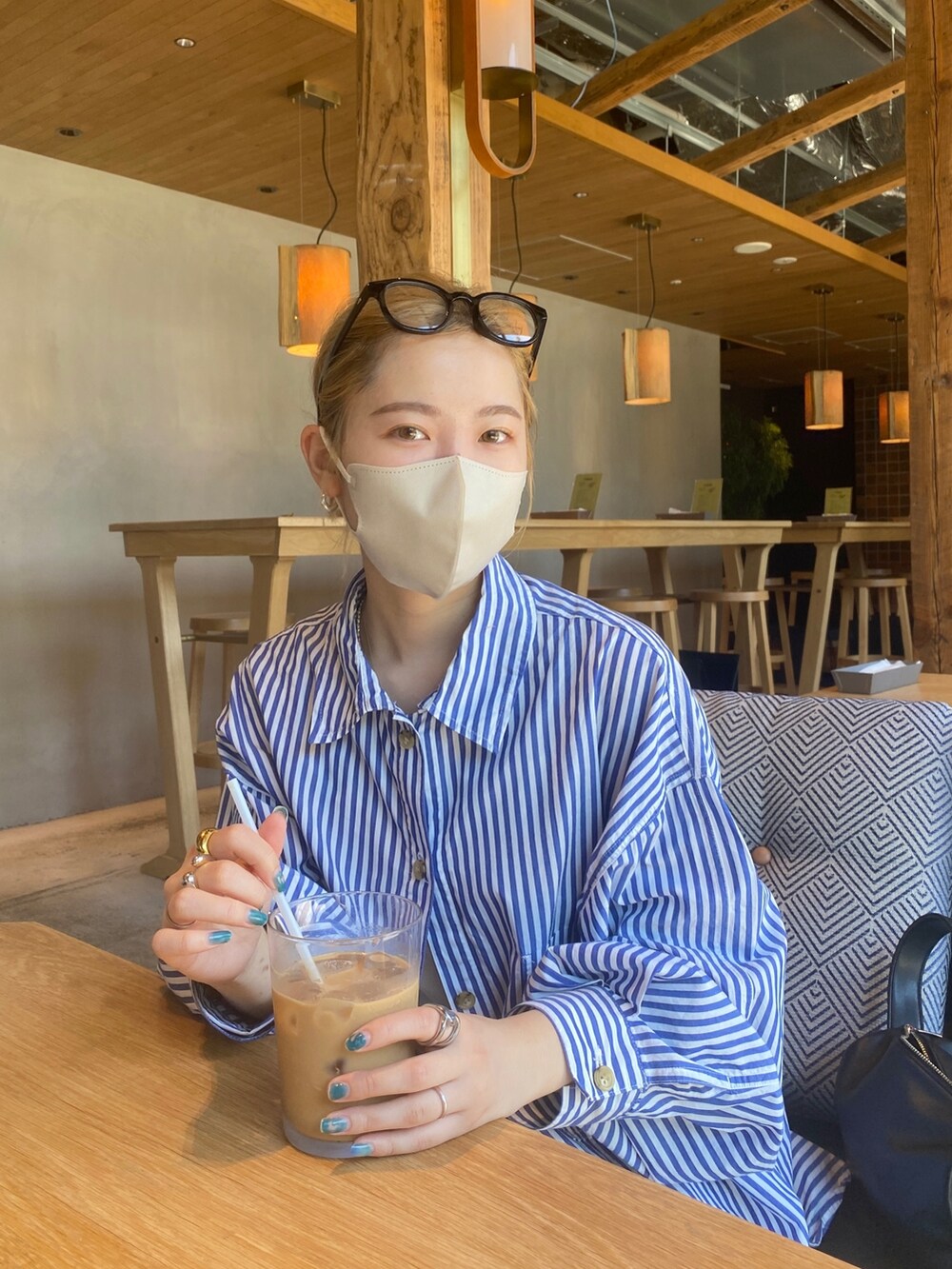 ブルー系のシャツ/ブラウス、グレー系のパンツ、ブラック系のサングラスを着用したレディースの夏コーディネートの4枚目の写真