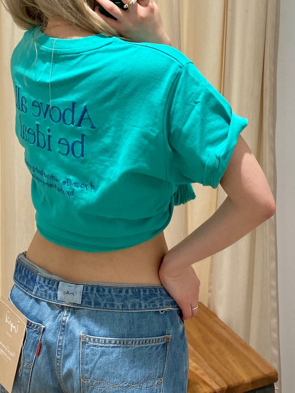 グリーン系のTシャツ/カットソー、ブルー系のデニムパンツを着用したレディースの春コーディネートの2枚目の写真