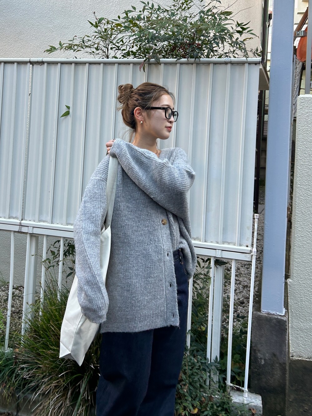 ブラック系のブルゾン、グレー系のカーディガン/ボレロ、ブルー系のデニムパンツを着用したレディースの冬コーディネートの6枚目の写真