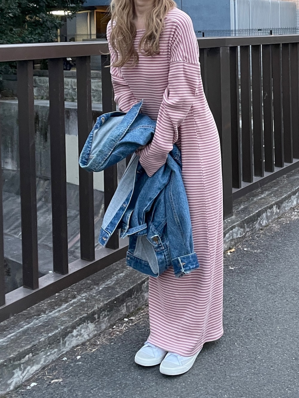 ピンク系のワンピース、ブルー系のデニムジャケット、グレー系のニットキャップ/ビーニーを着用したレディースの冬コーディネートの10枚目の写真