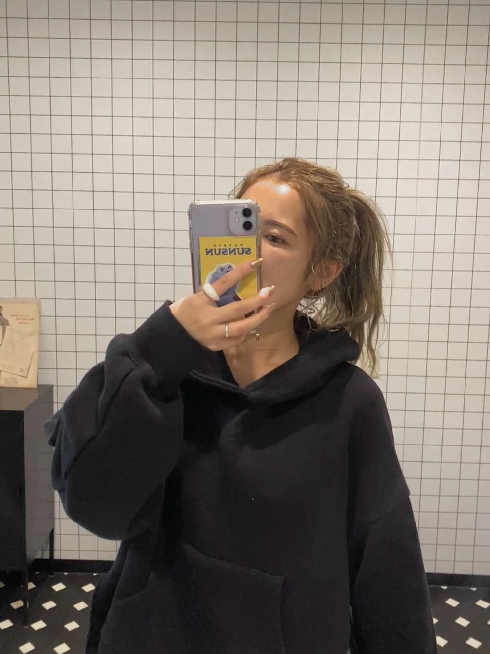 ブラック系のパーカー、ブルー系のデニムパンツを着用したレディースの秋コーディネートの3枚目の写真