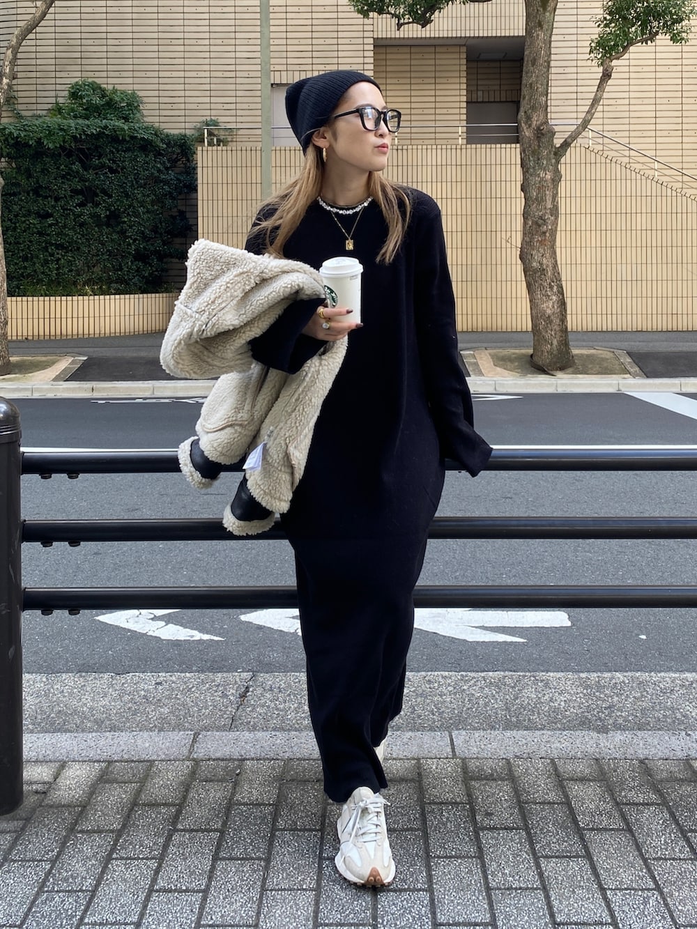 ブラック系のムートンコート、ブラック系のワンピース、ブラック系のニットキャップ/ビーニーを着用したレディースの冬コーディネートの4枚目の写真