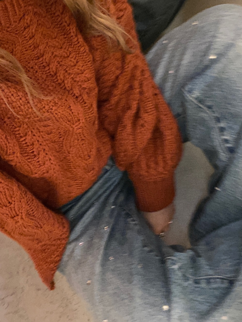 オレンジ系のニット/セーター、ブルー系のデニムパンツ、ブラック系のニットキャップ/ビーニーを着用したレディースの秋コーディネートの3枚目の写真